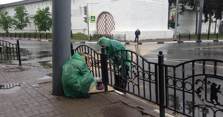 Фото дня. Рабочие в дождь красят заржавевшие заборы с медведями вокруг Богоявленской площади