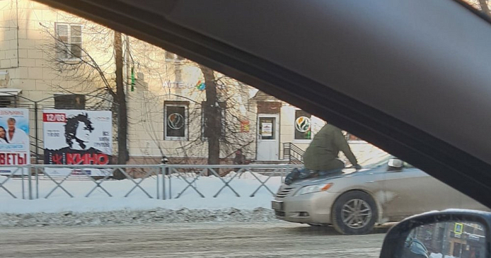 Фото дня. В центре Ярославля мужчина уселся на капот машины 